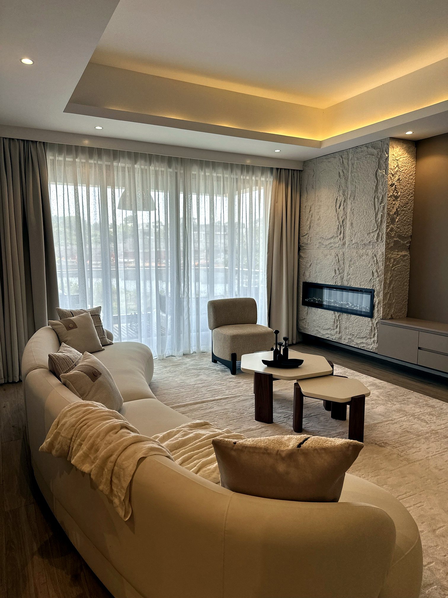 A neutral-toned living room with a stone feature wall